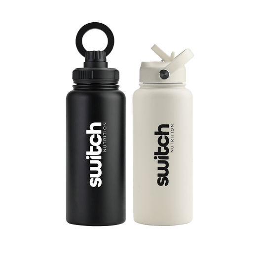 Two 1-litre stainless steel water bottles from Switch Nutrition. One bottle is matte black with a loop-top lid, while the other is matte white with a flip-top straw lid. Both feature the "Switch Nutrition" logo in bold black lettering.